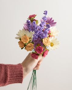 a person holding a bouquet of flowers in their hand