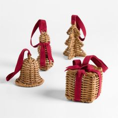 three small christmas trees made out of wicker with red ribbon tied around the top