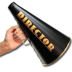 a hand holding a black and gold cone with the word director on it's side