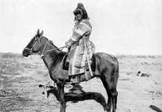 an old black and white photo of a man on a horse