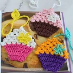 an open book with crocheted cupcakes on it