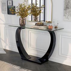 a glass and metal console table with vases on the top, mirror behind it