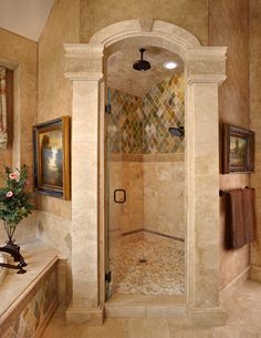 a bathroom with a walk in shower next to a sink and a mirror on the wall