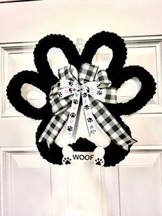 a black and white door hanger with a dog's paw print on it