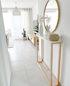 there is a mirror on the wall next to a shelf with vases and plants