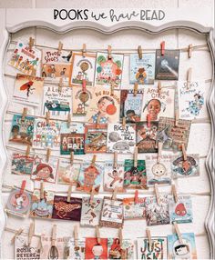 a bulletin board with pictures and clothes pins hanging on it's sides in front of a white wall