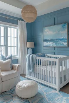 a baby's room with blue walls and white furniture, including a crib