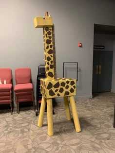 a giraffe made out of wooden sticks in an office