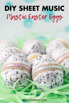 some white and black decorated eggs with music notes on them, sitting in the grass