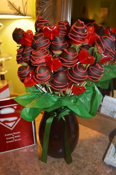 a vase filled with chocolate covered roses on top of a counter next to a mirror