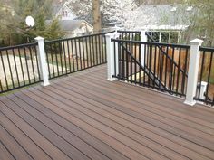 a deck with black iron railing and white posts