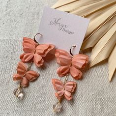 These elegant earrings are inspired by the happiness a butterfly brings. Hand dyed with natural dyes, these lightweight silk wings are linked on a single delicate chain. This stunning pair of earrings feature Swarovski crystals at the bottom to create a bit of sparkle and weight. Feeling confident and beautiful, you will find them easy to wear for special occasions or an elevated everyday look. Light peach colour. -Genuine Swarovski crystals -100% silk butterflies, hand dyed with natural dyes -1 Elegant Orange Flower Earrings For Gift, Butterfly Shaped Earrings For Summer Gifts, Peach Earrings For Summer Gift, Pink Butterfly Earrings For Summer, Pink Butterfly Jewelry For Summer, Orange Earrings For Summer Gifting, Orange Earrings For Spring Gift, Spring Gift Orange Earrings, Handmade Pink Butterfly Earrings