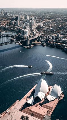 an aerial view of the sydney opera house and harbour bridge, with boats in the water