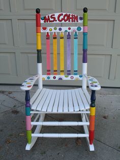 a white wooden rocking chair with crayons painted on it and the words ms cohn