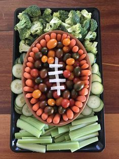 a bowl filled with veggies and a football cut out in the shape of a football