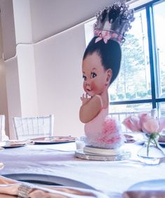 a baby doll cake sitting on top of a table with plates and napkins around it