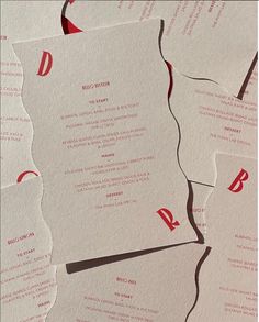 several pieces of white paper with red ink on them and some type of business card