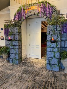 an entrance to a building with purple flowers on it