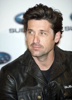 a close up of a person wearing a leather jacket and looking off to the side