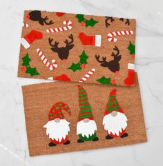 two christmas themed placemats sitting on top of a white marble counter next to each other