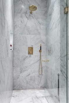 a walk in shower with marble walls and floor