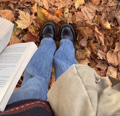 a person laying on the ground with their legs crossed and reading a book in front of them