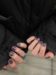 a woman with purple and silver nail polish holding her hands out to the camera while wearing black