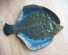 a fish shaped dish sitting on top of a wooden table