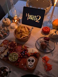 a table topped with lots of food next to a sign that says hocus pocus