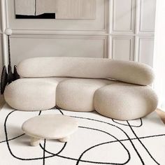 a white couch sitting on top of a black and white rug