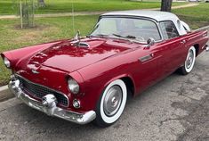 an old red and white car parked on the street