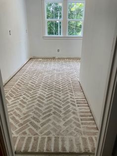 an empty room with carpeted floor and windows