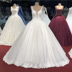 wedding gowns are displayed on mannequins in a store window