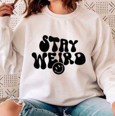 "PLEASE READ ENTIRE DESCRIPTION BEFORE ORDERING Stay Weird Sweatshirt, Stay Weird T Shirt, Gift for friend, Funny Gift, Funny Shirt, Tee  Fall in love with this soft and cozy Graphic Tee, Sweatshirt or hoodie  TO MAKE YOUR SHOPPING EXPERIENCE EASIER, YOU CAN \"CHOOSE\" A T SHIRT, SWEATSHIRT OR HOODIE IN THIS LISTING. Size up 1-2 sizes for a slouchy oversized fit Available in Shirt, Sweatshirt and Hoodie Tee Shirt Shirt Sleeve Crewneck Unisex 100% Cotton Sweatshirt and Hoodies Long Sleeve Soft 50 Funny Hoodies Humor, Casual Long Sleeve T-shirt With Funny Text, Casual Printed Crew Neck Sweatshirt, Printed Crew Neck Casual Sweatshirt, Casual Cotton Sweatshirt With Funny Print, Trendy Long Sleeve Tops With Funny Text, Trendy Long Sleeve T-shirt With Funny Print, Casual Crew Neck Shirt With Funny Print, Trendy Crew Neck Shirt With Slogan