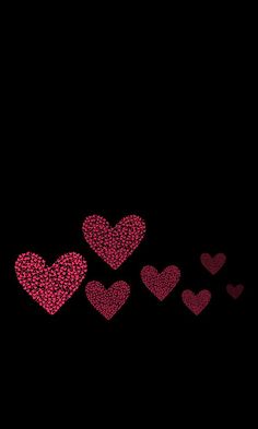 pink hearts flying in the air on a black background