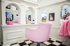 a pink chair sitting on top of a checkered floor