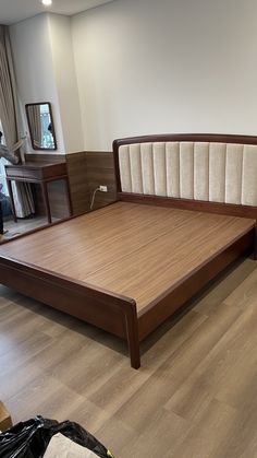 a bed with wooden headboard and foot board sitting in a room next to a window