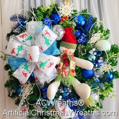 a wreath decorated with blue and white christmas decorations, snowman ornament and other holiday items