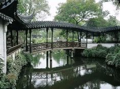 a bridge over a small pond in a park