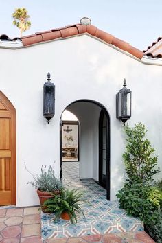 an entrance to a home with potted plants