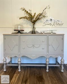 a white dresser with flowers on top of it