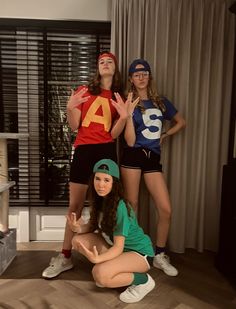 three young women dressed in costumes posing for the camera with their hands up and one holding her hand out