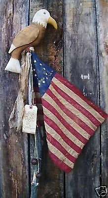 an american flag hanging from the side of a wooden wall with a bird on it