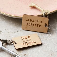 two personalized keychains on a plate with the name always and forever engraved on them