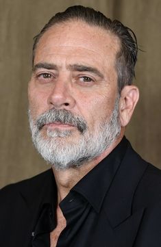 a man with grey hair and beard wearing a black shirt