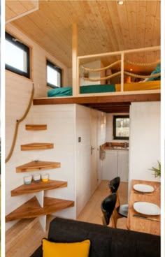 the interior of a tiny house with wood flooring and stairs leading up to the loft