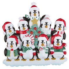 a group of penguins standing next to each other in front of a christmas tree and star