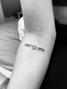 a woman's arm with a small tattoo on it that says, love 1974