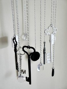 a bunch of keys hanging from a wall with chains attached to the back of them