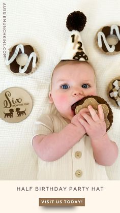 a baby in a party hat eating a cookie